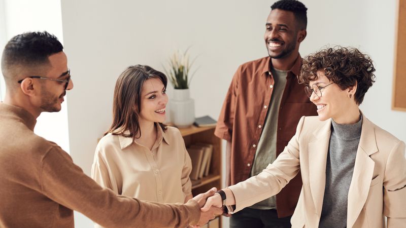 Colegas se cumprimentando em ambiente de trabalho colaborativo